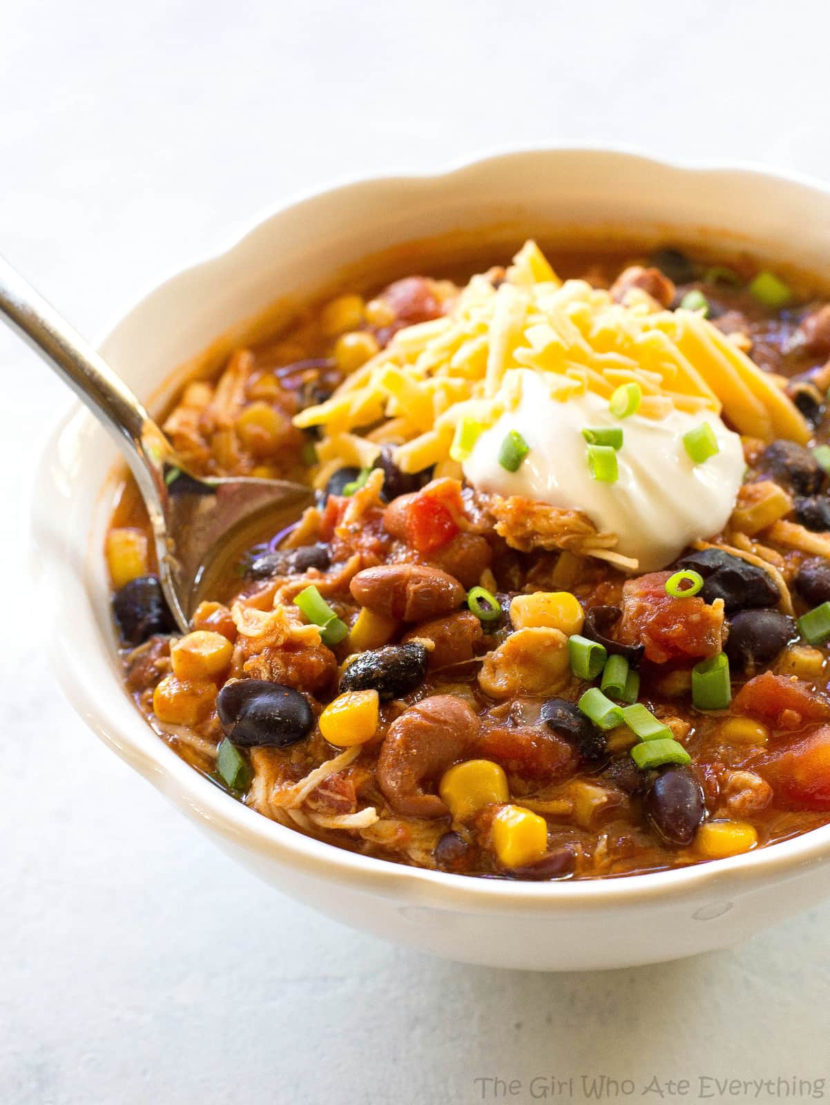 Chicken Taco Soup with sour cream and a spoon in it