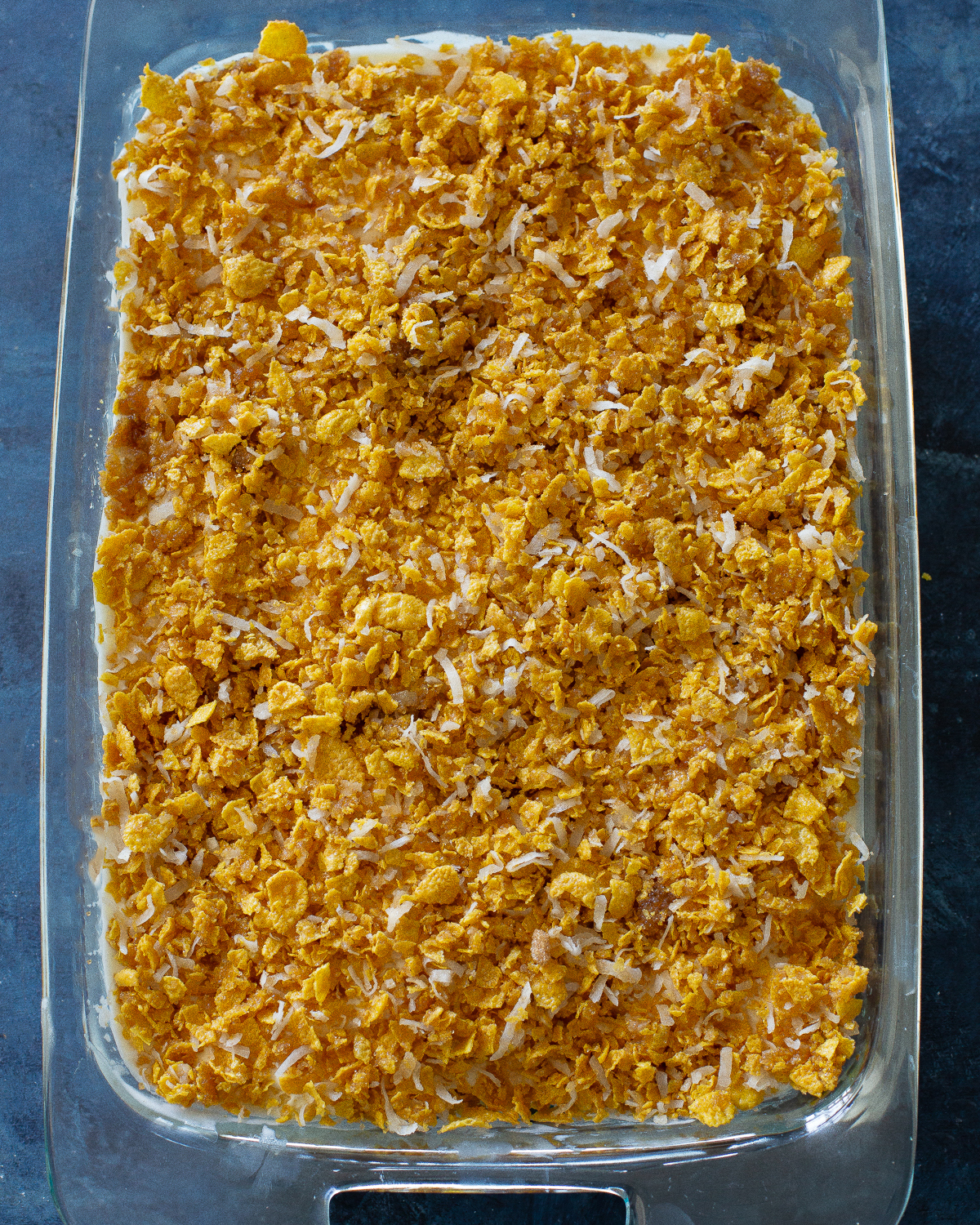 This Crunchy Ice Cream Dessert layers has of coconut, crushed cornflakes, brown sugar, and melted butter. #crispy #ice #cream #dessert