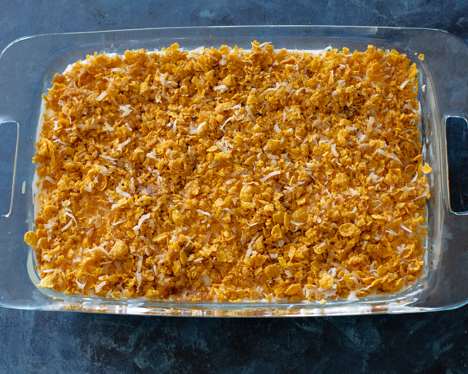 This Crunchy Ice Cream Dessert layers has of coconut, crushed cornflakes, brown sugar, and melted butter. #crispy #ice #cream #dessert