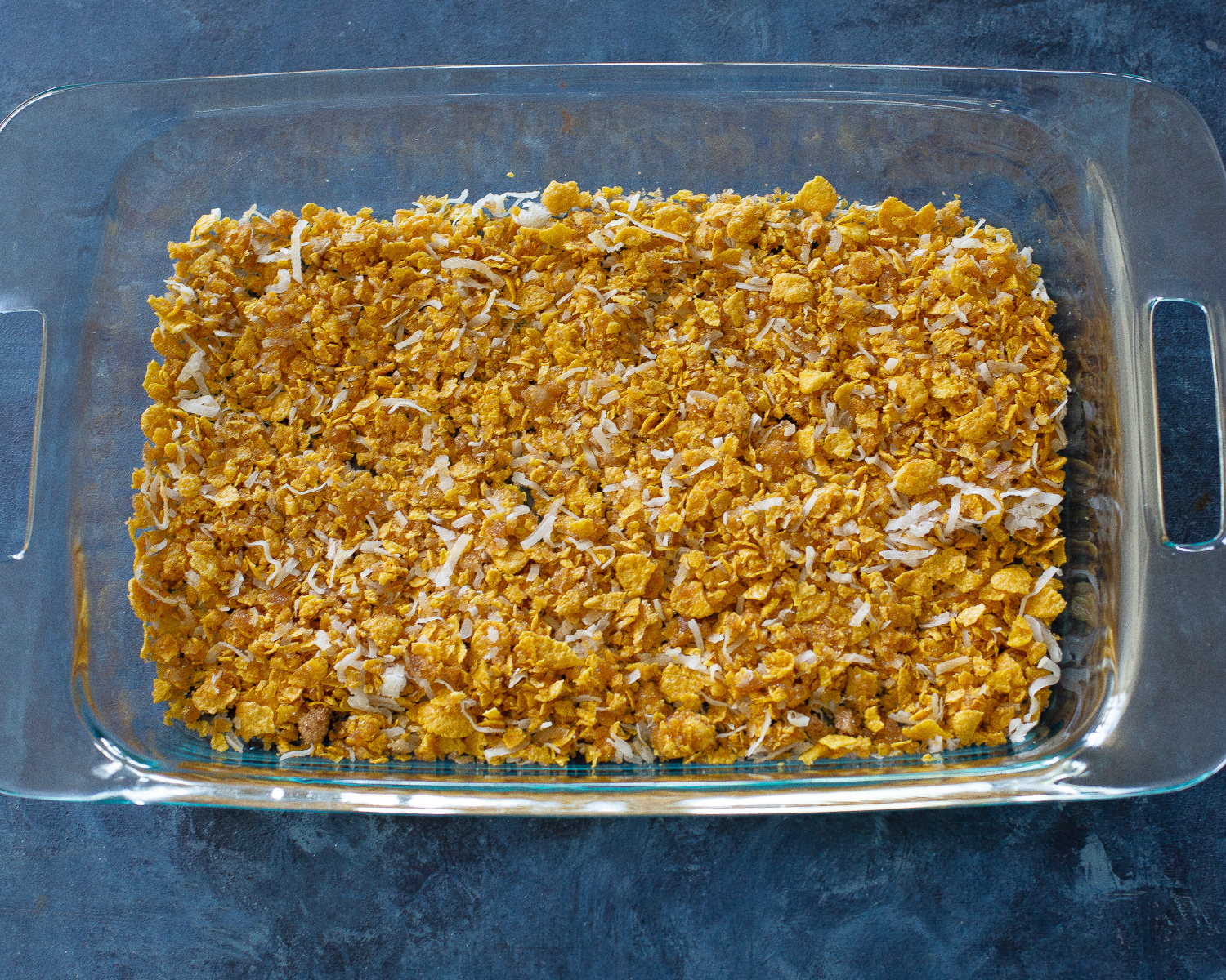 This Crunchy Ice Cream Dessert layers has of coconut, crushed cornflakes, brown sugar, and melted butter. #crispy #ice #cream #dessert