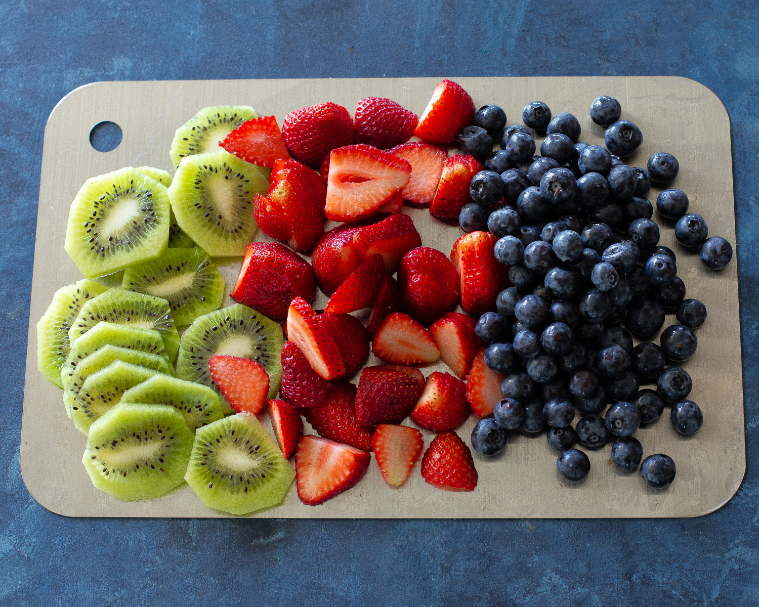 Fruit Pizza is a delicious dessert for a potluck. It starts with a sugar cookie base and a cream cheese frosting topped with assorted fruit. #fruit #pizza #dessert #recipe