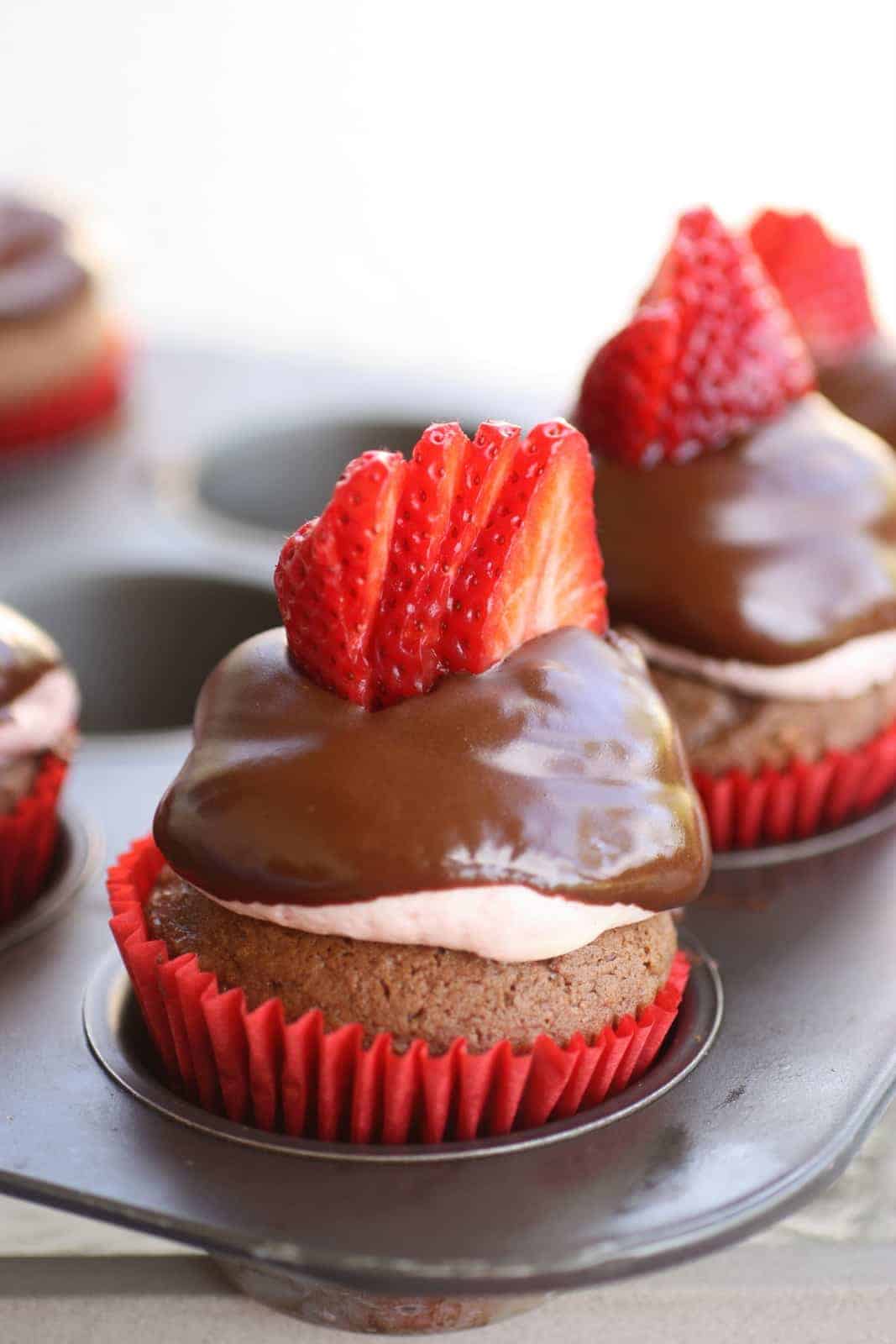 Strawberry Puffcakes - chocolate cupcakes topped with strawberry cream and dipped in chocolate. the-girl-who-ate-everything.com