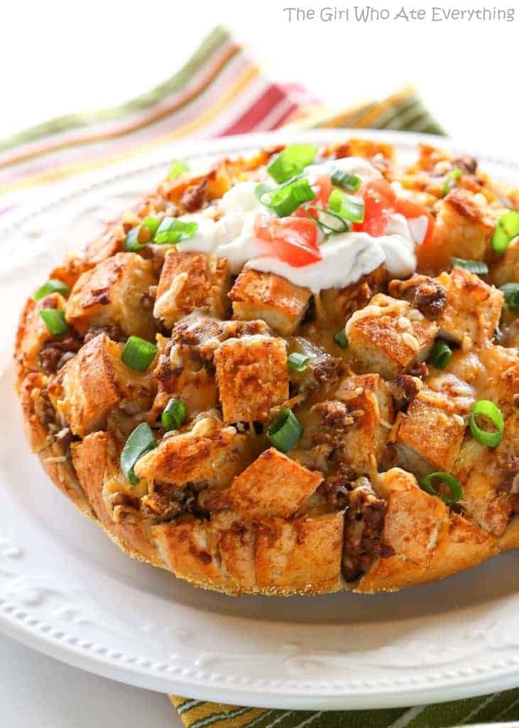 Taco Party Bread - A fun appetizer made with sourdough bread stuffed with taco meat, cheese, and topped with your favorite taco fixings. the-girl-who-ate-everything.com