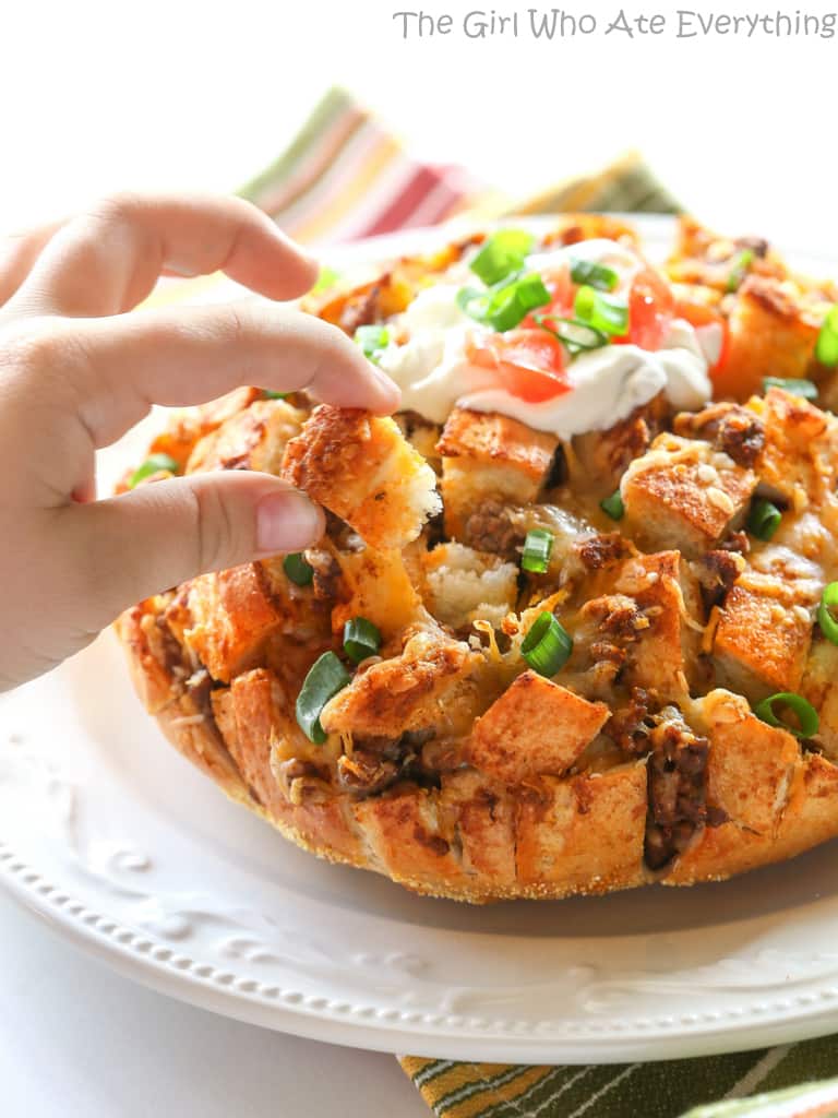 Taco Party Bread - A fun appetizer made with sourdough bread stuffed with taco meat, cheese, and topped with your favorite taco fixings. the-girl-who-ate-everything.com
