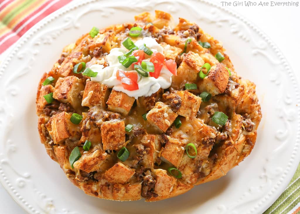 Taco Party Bread - A fun appetizer made with sourdough bread stuffed with taco meat, cheese, and topped with your favorite taco fixings. the-girl-who-ate-everything.com