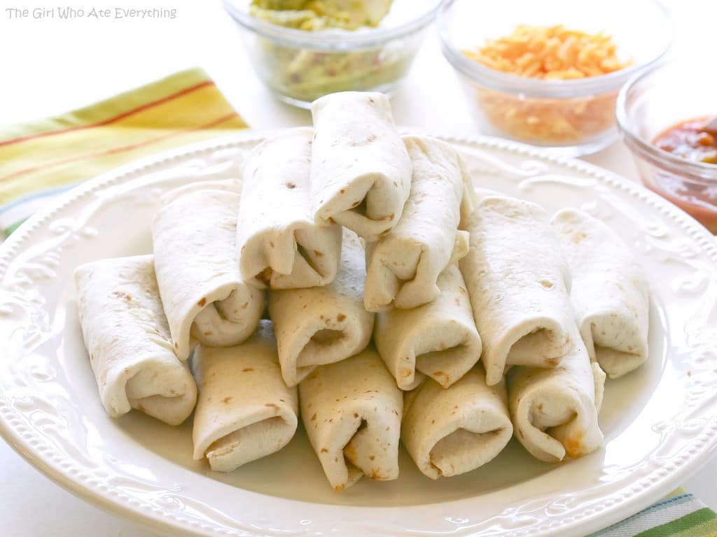 These Mini Burritos are filled with seasoned meat, beans, and cheese. Serve them as an appetizer and let your guests top their own. the-girl-who-ate-everything.com