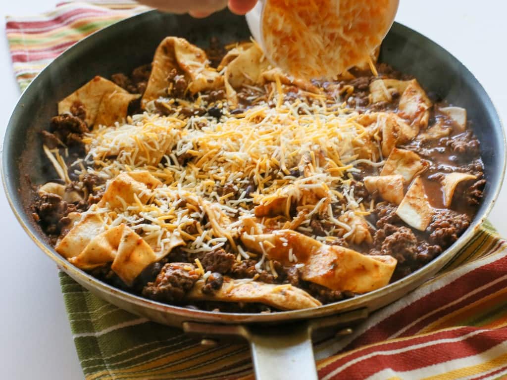 This Easy Beef Burrito Skillet has beef, black beans, salsa, and tortillas all cooked in one skillet. The tortillas turn soft and almost like a dumpling. This tasty dish is done in less than 20 minutes. the-girl-who-ate-everything.com