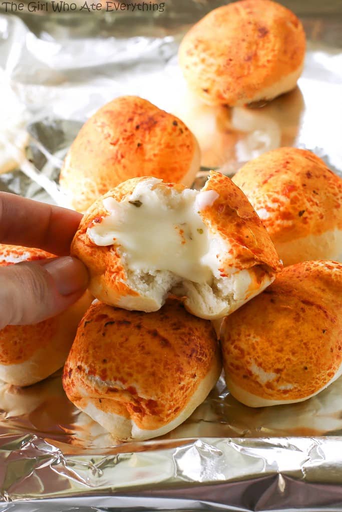 Mozzarella Puffs - dough stuffed with cubes of mozzarella cheese and brushed with pizza sauce. You could also add some pepperoni inside! These are so quick and easy. the-girl-who-ate-everything.com