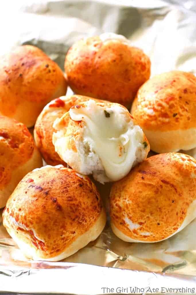 Mozzarella Puffs - dough stuffed with cubes of mozzarella cheese and brushed with pizza sauce. You could also add some pepperoni inside! These are so quick and easy. the-girl-who-ate-everything.com