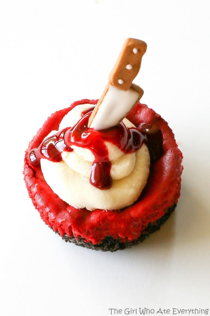 Mini Red Velvet Cheesecakes - moist red velvet cheesecake with an Oreo crust. The best recipe I've ever had. Topped with cream cheese for the ultimate indulgence. Add some edible blood for a dramatic Halloween dessert. the-girl-who-ate-everything.com