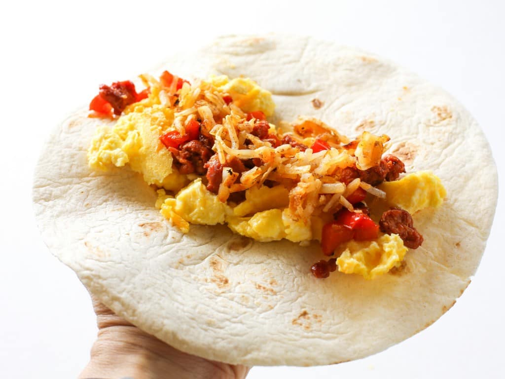 These Chorizo Breakfast Enchiladas are filled with eggs, chorizo, hash browns and topped with bacon! the-girl-who-ate-everything.com