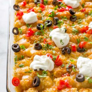 Tater Taco Casserole - A Mexican mixture of taco meat, beans, corn, and cheese topped with tater tots and enchilada sauce. the-girl-who-ate-everything.com