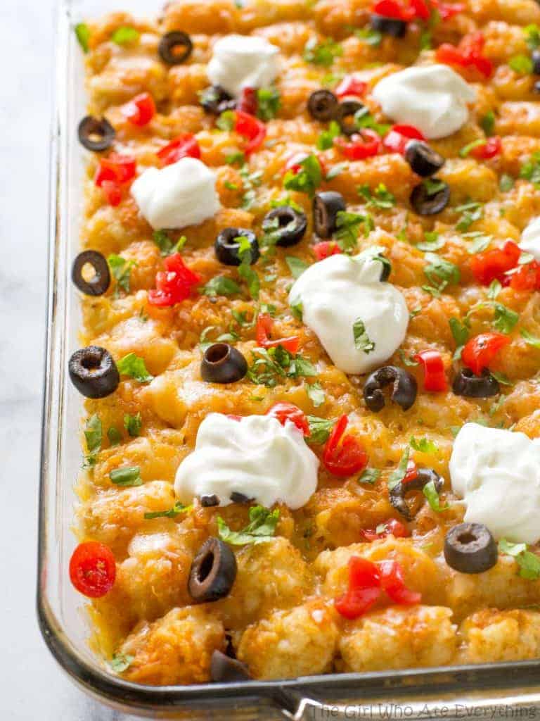 Tater Taco Casserole - A Mexican mixture of taco meat, beans, corn, and cheese topped with tater tots and enchilada sauce. the-girl-who-ate-everything.com