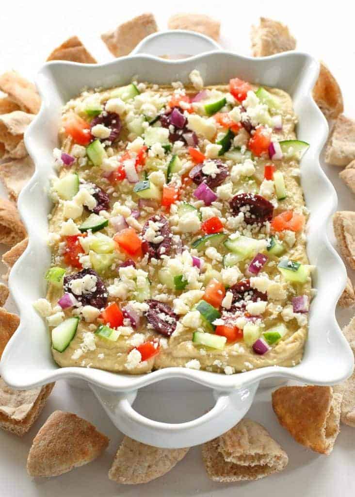 Greek Layered Hummus - If you want a quick and delicious snack, this Greek Layered Hummus is perfect! With the help of premade hummus, this snack comes together quickly and is full of flavor!