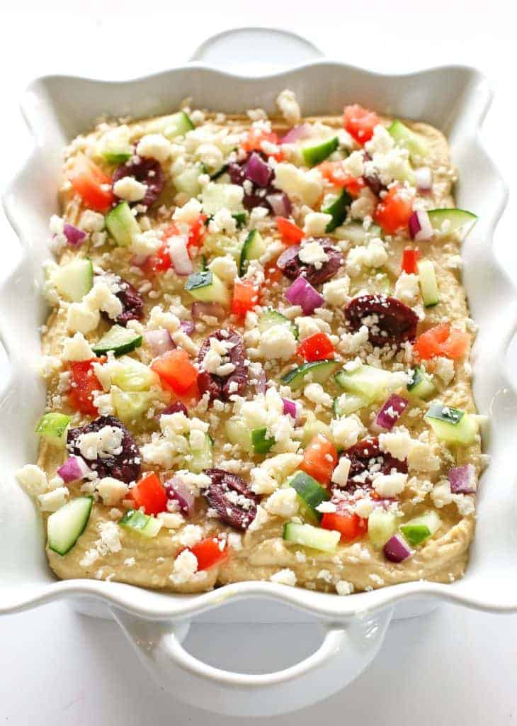 Greek Layered Hummus - If you want a quick and delicious snack, this Greek Layered Hummus is perfect! With the help of premade hummus, this snack comes together quickly and is full of flavor!