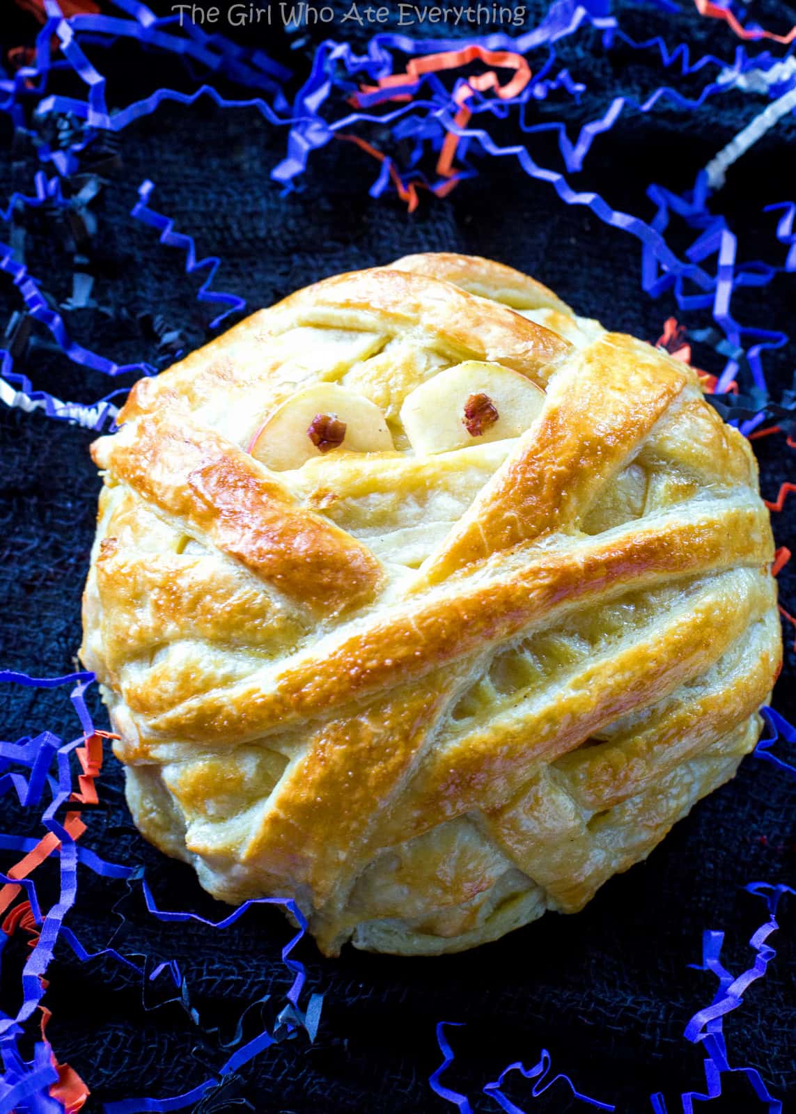 Mummy Wrapped Brie - topped with brown sugar and cinnamon pecans, baked inside puff pastry until nice and gooey. The best appetizer for Halloween! the-girl-who-ate-everything.com
