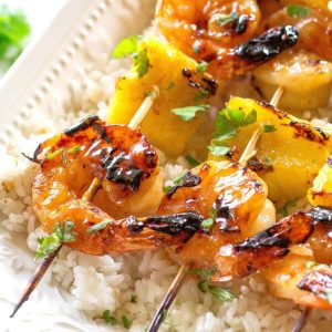These Grilled Shrimp and Pineapple Skewers are served over coconut rice and have a sweet Teriyaki glaze. the-girl-who-ate-everything.com