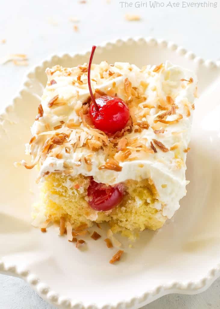 Pina Colada Poke Cake - drizzled with coconut and pineapple and topped with coconut whipped cream and toasted coconut, this cake is the best summer cake out there. the-girl-who-ate-everything.com