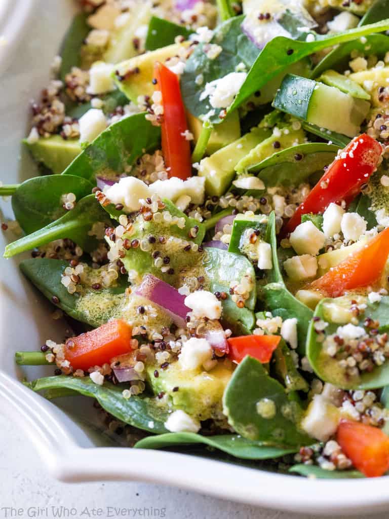 Spinach Quinoa Salad - full of rich healthy foods like cucumber, red bell pepper, avocado, and onion. This recipe is topped with a lemon dijon vinaigrette. the-girl-who-ate-everything.com