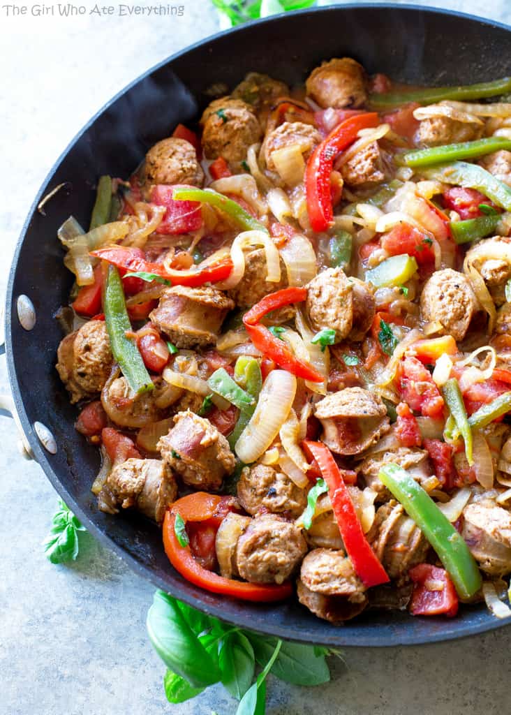 sliced sausage, green and red bell peppers and onions in a pan