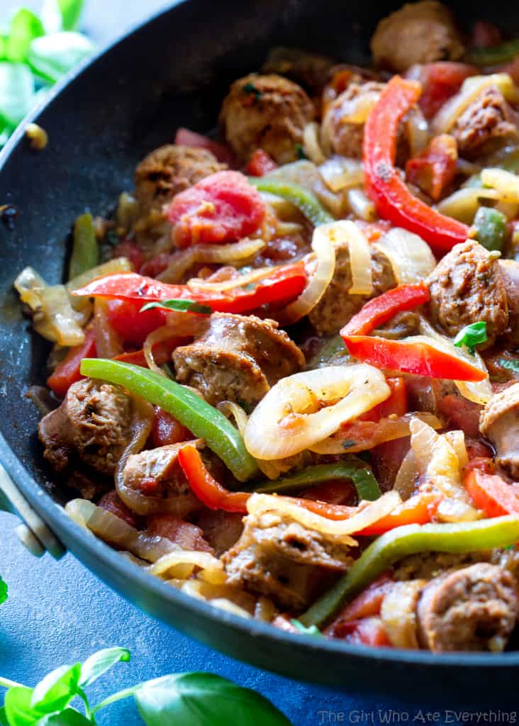 sliced sausage, green and red bell peppers and onions in a pan