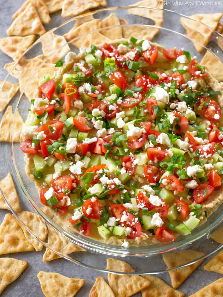 This Mediterranean 7-Layer Dip has layers of homemade tzatziki, hummus, cucumber, tomatoes, green onions, and feta..