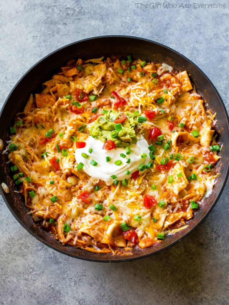 One Pan Chicken Enchilada Skillet enchilada sauce, chicken, tortillas, and salsa topped with sour cream and green onions