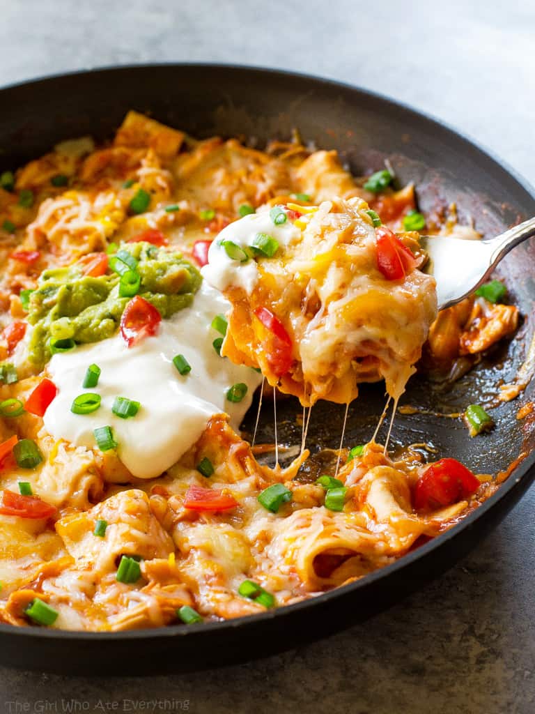 One Pan Chicken Enchilada Skillet enchilada sauce, chicken, tortillas, and salsa topped with sour cream and green onions