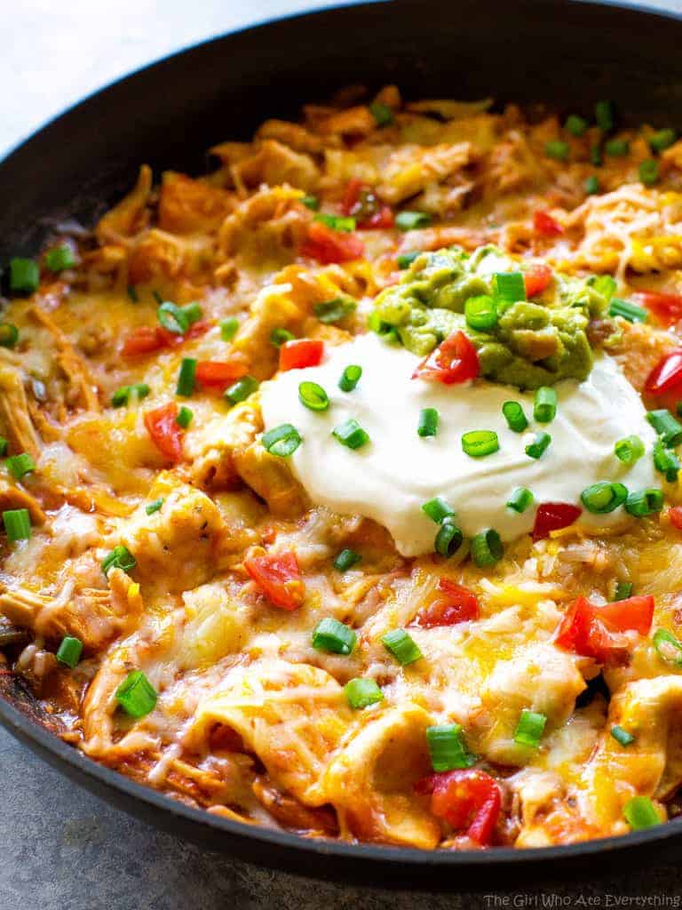 One Pan Chicken Enchilada Skillet enchilada sauce, chicken, tortillas, and salsa topped with sour cream and green onions