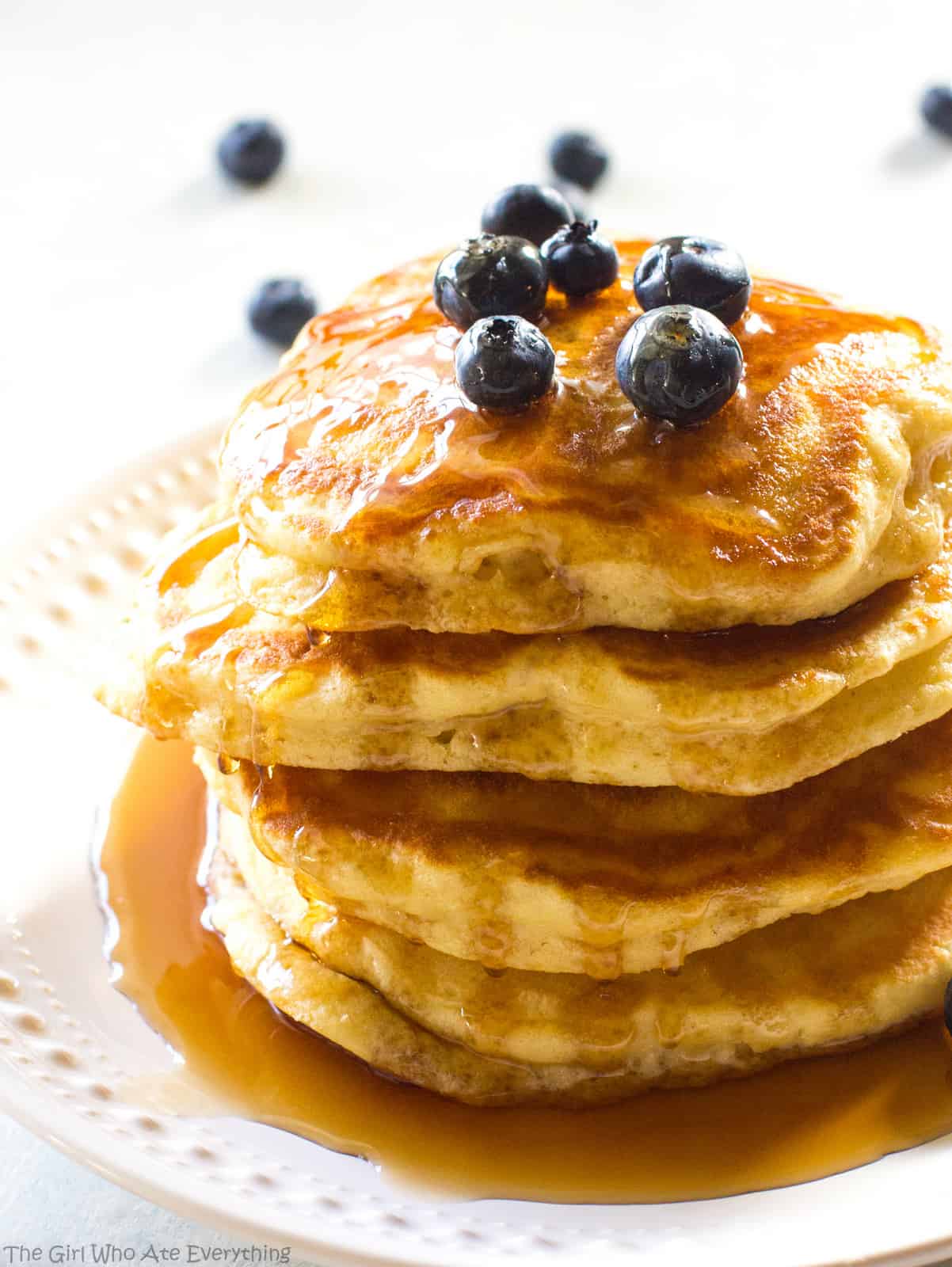 Fluffy pancakes and blueberries with syrup on a plate