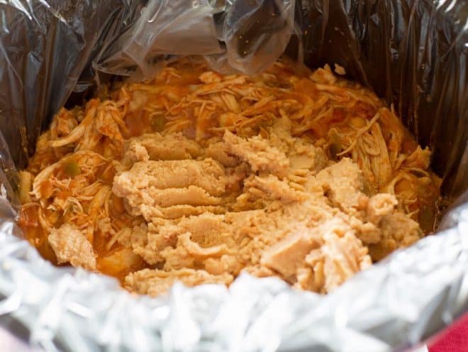 Cheesy Bean Salsa Chicken with refried beans in a slow cooker