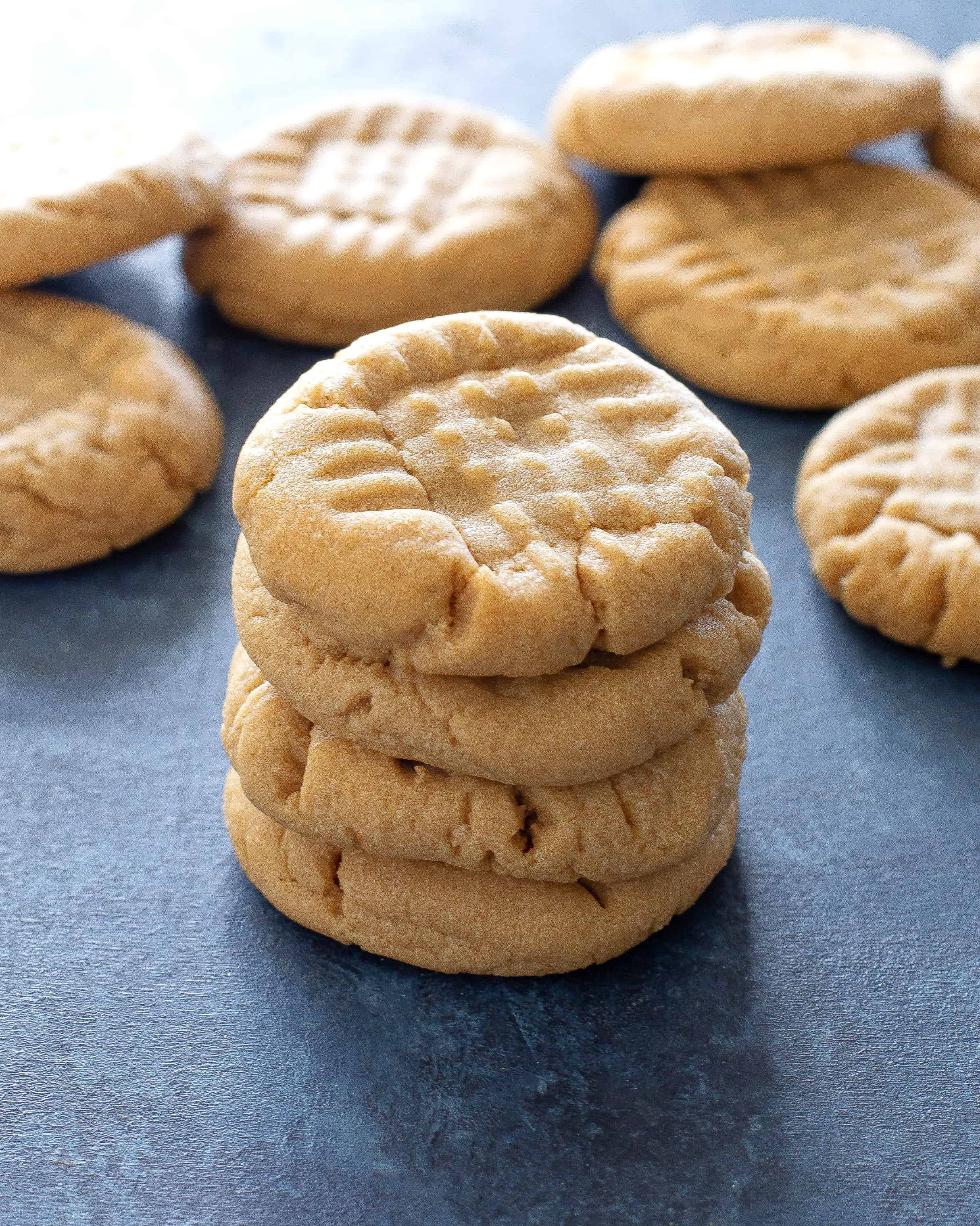 peanut butter cookies in a stack on a blue background