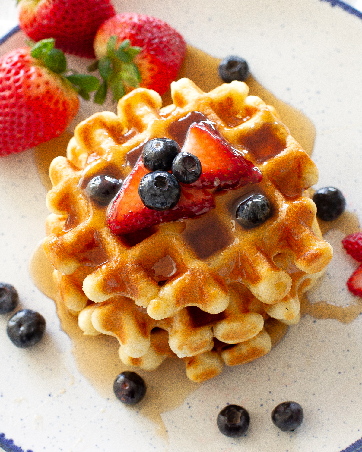 stack of waffles with strawberries and blueberries