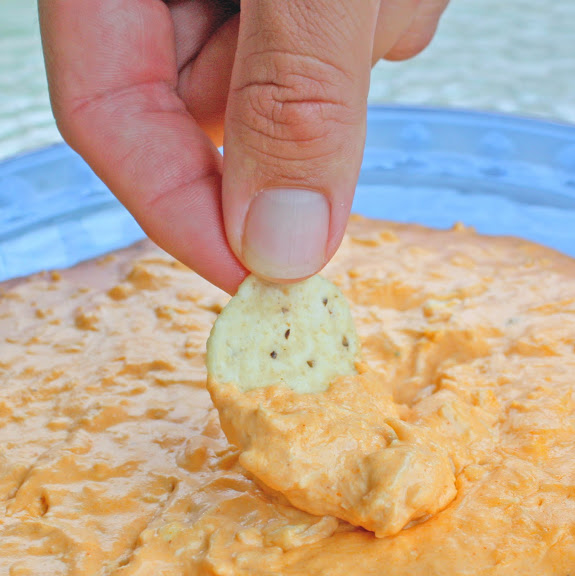 hand dipping in buffalo dip